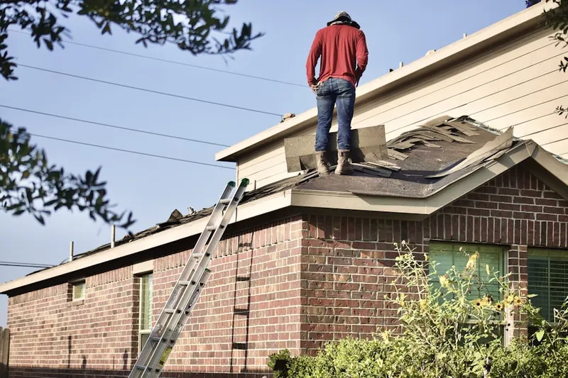 Professional roofer working on a residential roof in Fulton